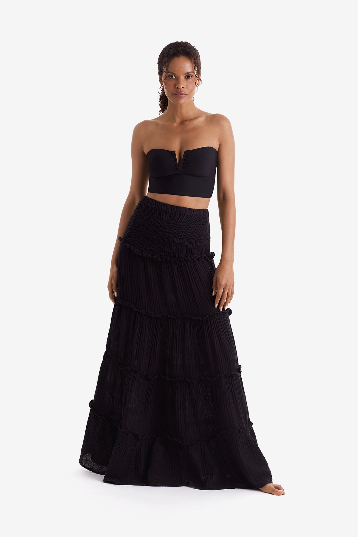 Woman wearing a black bandeau top and black floor length skirt